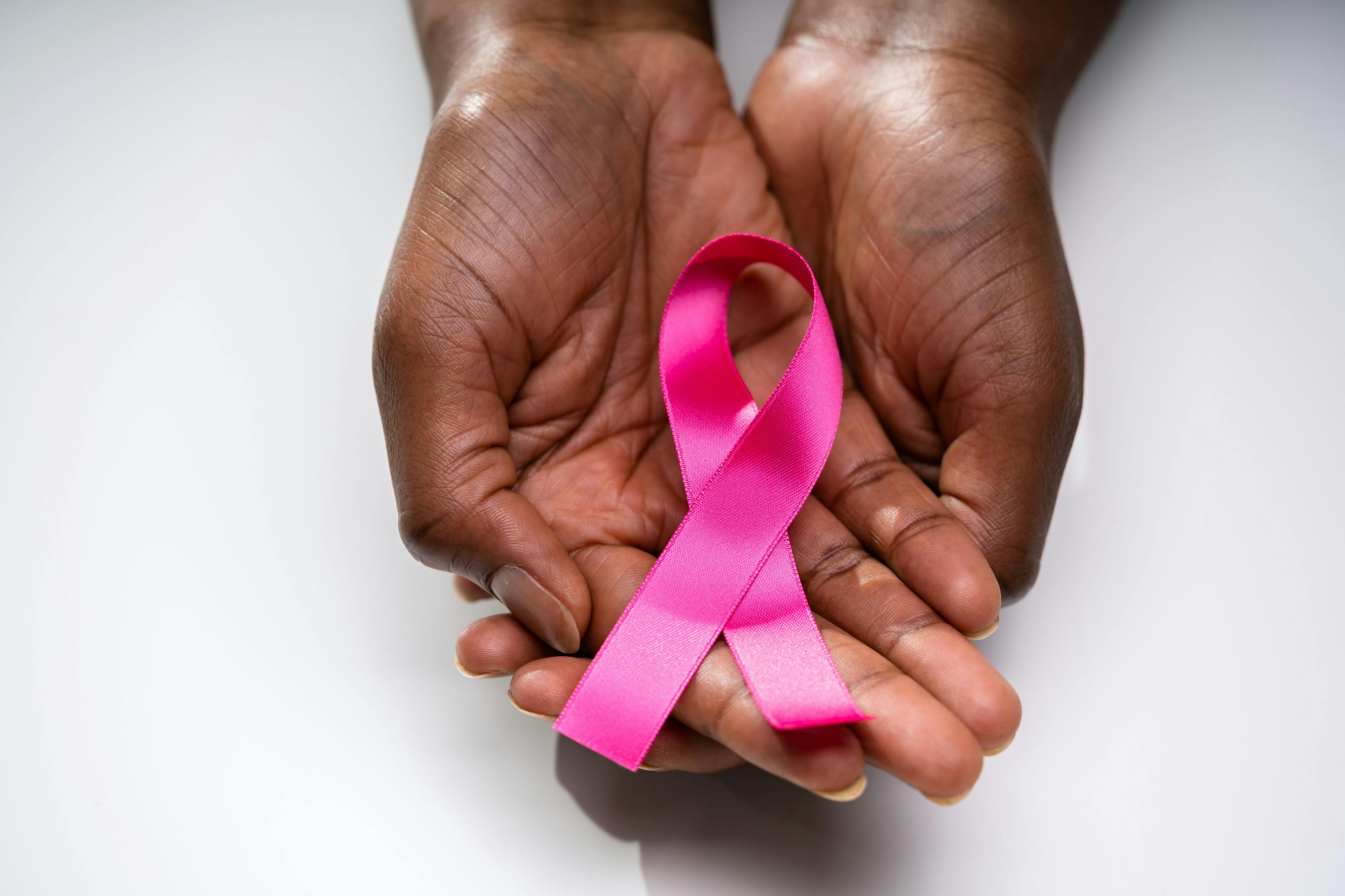 African American hands holding a pink ribbon