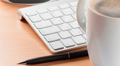 pen, keyboard and cup of coffee